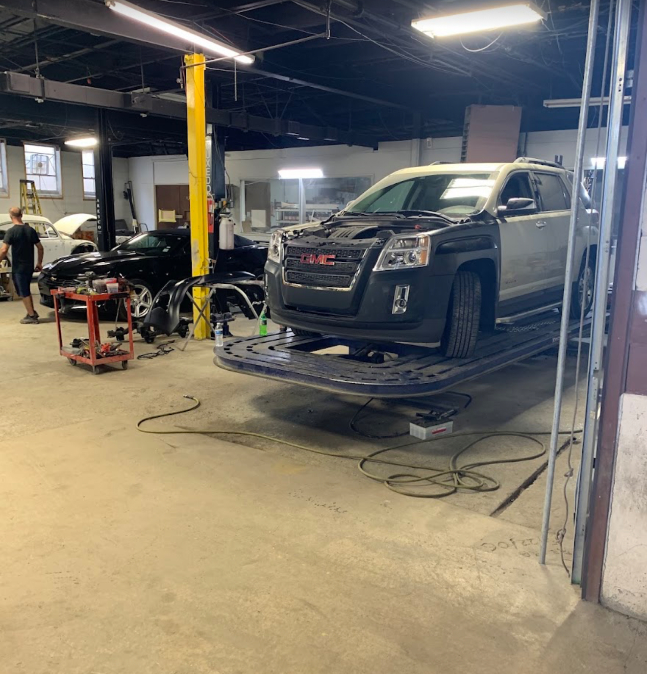 Inside DM Body Shop with a GMC SUV undergoing collision repair